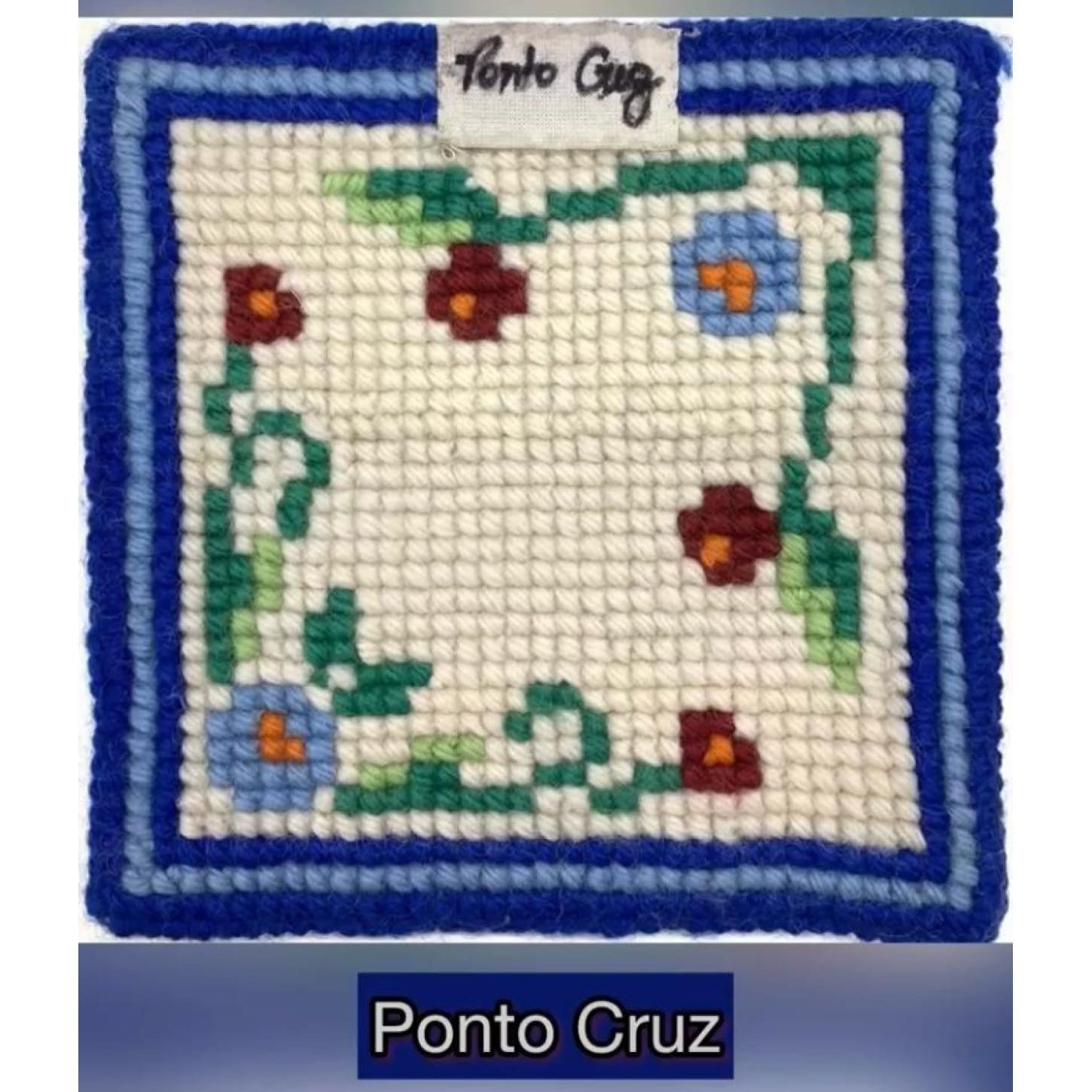 Amostra de tapeçaria em lã com moldura azul e flores